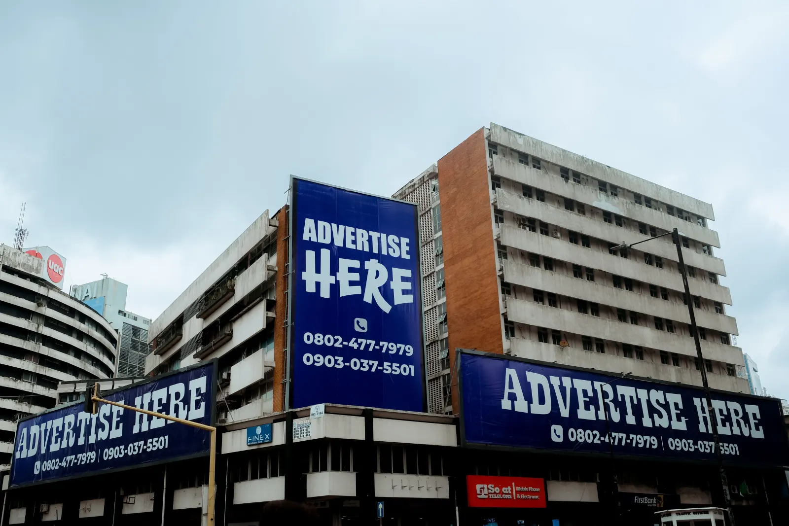 Rue animée de Kaduna, au Nigeria, bordée de grands panneaux publicitaires